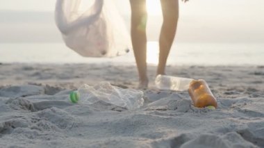 Su tasarrufu. Gönüllü olarak plajdaki çöpleri topluyor ve plastik şişeler suda yaşayan canlılara zarar gelmesini engelliyor. Dünya, Çevre, Yeşilci Gezegen, küresel ısınmayı azaltmak, Dünya 'yı kurtarmak