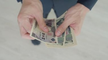Japon Yen parası. Japon yenini elinizin altında tutun. Japonya 'nın değişim, alım, satım, birikim, yatırım, finans, döviz kuru, değer, muhasebe, uluslararası döviz kurunda kullanılan para birimi