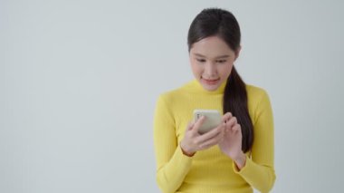 Asian beautiful woman exited surprise face expression . female feels shocked with the phone. exciting smile and happy adorable rejoices. Very enjoy and fun relax time. wow, girl holding smartphone.