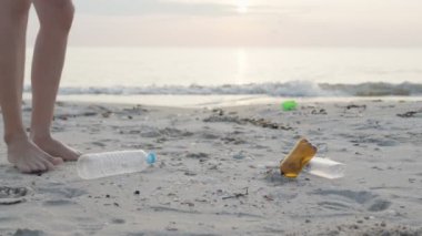 Su tasarrufu. Gönüllü olarak plajdaki çöpleri topluyor ve plastik şişeler suda yaşayan canlılara zarar gelmesini engelliyor. Dünya, Çevre, Yeşilci Gezegen, küresel ısınmayı azaltmak, Dünya 'yı kurtarmak