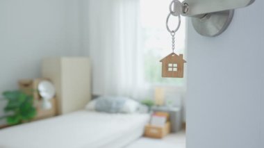 Moving house, relocation. The key was inserted into the door of the new house, inside the room was a cardboard box containing personal belongings and furniture. move in the apartment or condominium