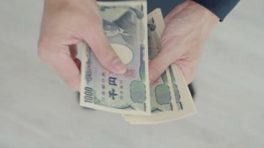 Japanese Yen money. close up of the Japanese yen on hand. currency of Japan that is used to change, buy, sell, accumulate, invest, financial, exchange rate, value, accounting, international exchange