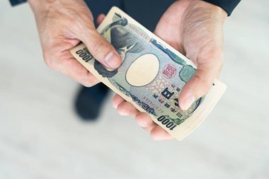 Japon Yen parası. Japon yenini elinizin altında tutun. Japonya 'nın değişim, alım, satım, birikim, yatırım, finans, döviz kuru, değer, muhasebe, uluslararası takas için kullanılan para birimi