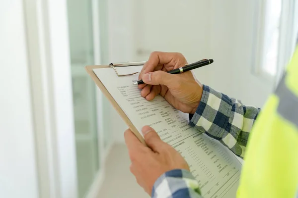 stock image inspector or engineer is inspecting construction and quality assurance new house using a checklist. Engineers or architects or contactor work to build the house before handing it over to the homeowner