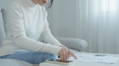Modern kadın, internet üzerinden belge faturasını aldıktan sonra kredi kartı faturasını ödemek için barkod veya QR kodlarını taramak için telefon kullanıyor. Ödeme, ödeme, ödeme elektrik, dijital ödemeler para, teknoloji, tarama olmadan