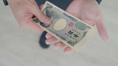 Japon Yen parası. Japon yenini elinizin altında tutun. Japonya 'nın değişim, alım, satım, birikim, yatırım, finans, döviz kuru, değer, muhasebe, uluslararası döviz kurunda kullanılan para birimi
