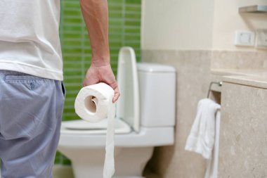 Kabızlık ve ishal banyoda. Yaralı adam karnına dokunuyor. Karın ağrısı. kolon iltihabı sorunu, zehirli besin, karın ağrısı, karın ağrısı, tuvalette kabızlık, mide ağrısı, hijyen...