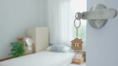 Moving house, relocation. The key was inserted into the door of the new house, inside the room was a cardboard box containing personal belongings and furniture. move in the apartment or condominium