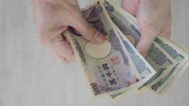 Japon Yen parası. Japon yenini elinizin altında tutun. Japonya 'nın değişim, alım, satım, birikim, yatırım, finans, döviz kuru, değer, muhasebe, uluslararası döviz kurunda kullanılan para birimi