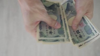 Japon Yen parası. Japon yenini elinizin altında tutun. Japonya 'nın değişim, alım, satım, birikim, yatırım, finans, döviz kuru, değer, muhasebe, uluslararası döviz kurunda kullanılan para birimi