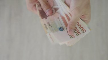 The currency of Korea which is used to represent value in exchange and the won is the main currency of Korean people. Korean won notes for money concept background.
