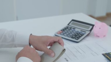 Yüklü faturaları ve faturaları olan stresli ve baş ağrısı çeken Asyalı bir adamın harcamaları ve kredi kartı borçlarını ödeyecek parası yok. kıtlık, mali sorunlar, mortgage, kredi, iflas, iflas, yoksul, boş cüzdan
