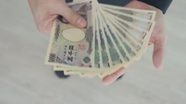 Japon Yen parası. Japon yenini elinizin altında tutun. Japonya 'nın değişim, alım, satım, birikim, yatırım, finans, döviz kuru, değer, muhasebe, uluslararası döviz kurunda kullanılan para birimi