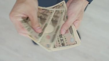 Japanese Yen money. close up of the Japanese yen on hand. currency of Japan that is used to change, buy, sell, accumulate, invest, financial, exchange rate, value, accounting, international exchange