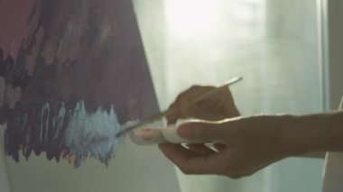 Profesyonel kadın sanatçı kız, sanat eseri yaratmak için soyut sanatlarda boya fırçası kullanır. Stüdyoda suluboya ya da yağlı boya boya. Güzel bir kadın resim yapmaktan zevk alır. iş eğlencesi