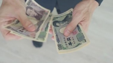 Japanese Yen money. close up of the Japanese yen on hand. currency of Japan that is used to change, buy, sell, accumulate, invest, financial, exchange rate, value, accounting, international exchange