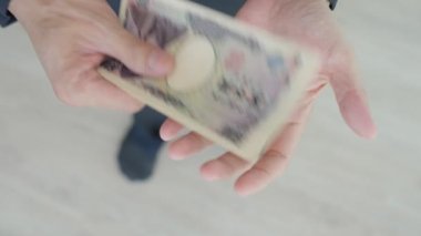 Japon Yen parası. Japon yenini elinizin altında tutun. Japonya 'nın değişim, alım, satım, birikim, yatırım, finans, döviz kuru, değer, muhasebe, uluslararası döviz kurunda kullanılan para birimi