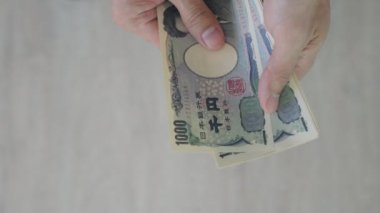 Japon Yen parası. Japon yenini elinizin altında tutun. Japonya 'nın değişim, alım, satım, birikim, yatırım, finans, döviz kuru, değer, muhasebe, uluslararası döviz kurunda kullanılan para birimi