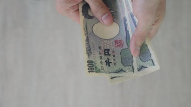 Japanese Yen money. close up of the Japanese yen on hand. currency of Japan that is used to change, buy, sell, accumulate, invest, financial, exchange rate, value, accounting, international exchange