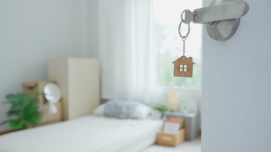 Moving house, relocation. The key was inserted into the door of the new house, inside the room was a cardboard box containing personal belongings and furniture. move in the apartment or condominium