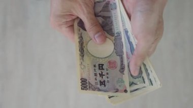 Japon Yen parası. Japon yenini elinizin altında tutun. Japonya 'nın değişim, alım, satım, birikim, yatırım, finans, döviz kuru, değer, muhasebe, uluslararası döviz kurunda kullanılan para birimi