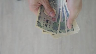 Japanese Yen money. close up of the Japanese yen on hand. currency of Japan that is used to change, buy, sell, accumulate, invest, financial, exchange rate, value, accounting, international exchange