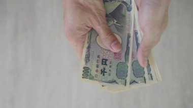Japon Yen parası. Japon yenini elinizin altında tutun. Japonya 'nın değişim, alım, satım, birikim, yatırım, finans, döviz kuru, değer, muhasebe, uluslararası döviz kurunda kullanılan para birimi