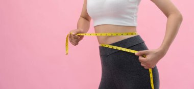 Diyet ve diyet. Güzel, ince kadın vücut ölçüsü. Spor elbiseli bir kadın sağlıklı yaşam için kilo verme hedefine, zayıflığa, ince belliye, beslenme uzmanına ulaşır.