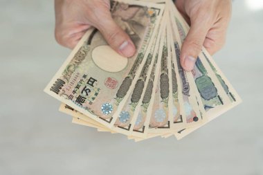 Japon Yen parası. Japon yenini elinizin altında tutun. Japonya 'nın değişim, alım, satım, birikim, yatırım, finans, döviz kuru, değer, muhasebe, uluslararası döviz kurunda kullanılan para birimi