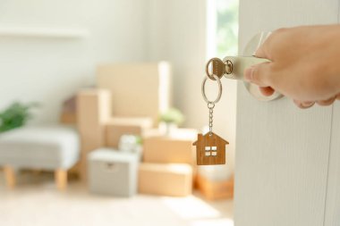 Moving house, relocation. Man hold key house keychain in new apartment. move in new home. Buy or rent real estate. flat tenancy, leasehold property, new landlord, investment, dwelling, loan, mortgage.