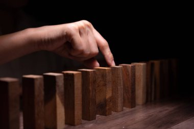 Domino 'yu elleri olan sigorta korur. İş adamı elleri iş krizinde domino taşlarının düşmesini durdurur. işletme risk denetimi ve planlama ve işletmeler sigorta işletmelerini önlemek için stratejiler.