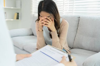 Akıl sağlığı sorunları olan bir kadın danışmanlık yapıyor. Psikiyatrist tedavi için hastanın durumunu kaydediyor. teşvik, sevgi ve aile sorunu, bipolar, depresyon hastası, intiharı koru