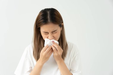 Polen alerjisi, mendile hapşıran Asyalı genç bir kadın veya mendile üfleyerek bahar çiçeklerine ya da bahar çiçeklerine alerjisi olan bir kadın. alerjik reaksiyon, solunum sistemi sorunu