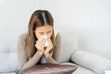 Baş ağrısı olan hasta bir kadın battaniyenin altında oturuyor, kadın hapşırıyor ve burnu akıyor mevsimsel grip, alerji, yüksek ateş ve grip, dinlenme, virüs, koronavirüs, hastalığı hisset, solunum