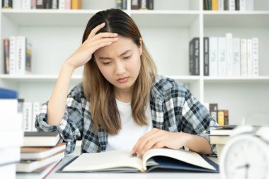Asian student woman have anxiety because of exams, female prepare for test and learning lessons in the library. stress, despair, haste, misunderstanding reading, discouraged, expectation, knowledge