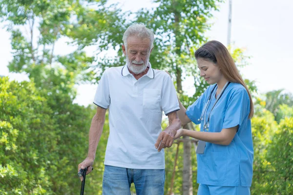 老年人在医院与医生和护士交谈 老年男性在接受治疗 护理和实习后 从专业医生那里散步 感到快乐 — 图库照片