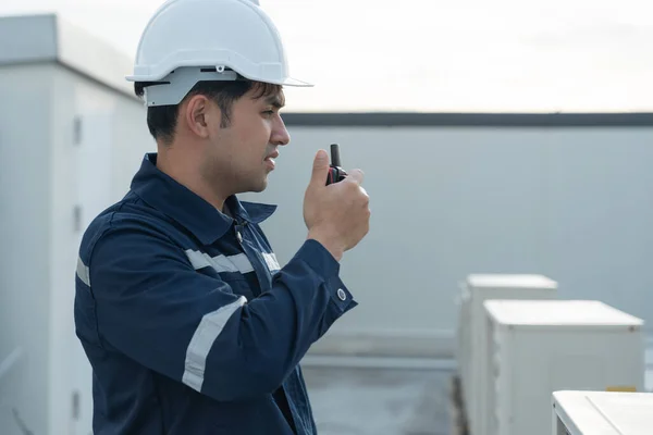 Asian maintenance engineer work on the roof of factory. contractor inspect compressor system and plans installation of air condition systems in construction. technology, walky talky, maintenance