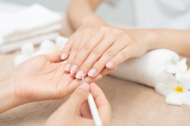 Woman receive care service by professional Beautician Manicure at spa centre. Nail beauty salon use nail file for Glazing treatment. manicurist make nail customer to beautiful. body care spa treatmen clipart
