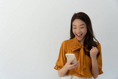 Asian beautiful woman exited surprise face expression . female feels shocked with the phone. exciting smile and happy adorable rejoices. Very enjoy and fun relax time. wow, girl holding smartphone.