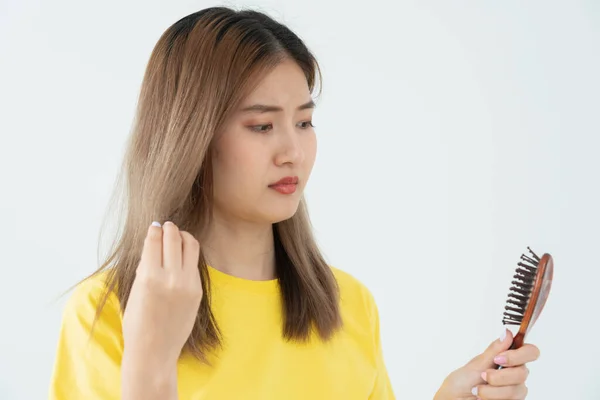 stock image Asian woman very sad and upset looking at damaged hair, hair loss, hair thinning problem, vitamin deficiency, baldness, postpartum, biotin, zinc, menstrual or endocrine disorders, hormonal imbalance