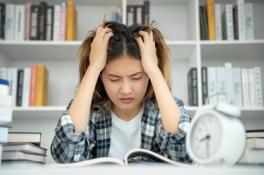 Asian student woman have anxiety because of exams, female prepare for test and learning lessons in the library. stress, despair, haste, misunderstanding reading, discouraged, expectation, knowledge
