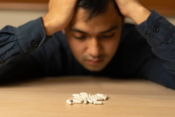 stock image asian man use pills overdose, stressed, sad, drug abuser, drug addict, sick, unhealthy, unhappy, suicide, depressed or hopeless, Anti drug, drug addict, life and family problems, unmotivated