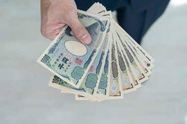 Japanese Yen money. close up of the Japanese yen on hand. currency of Japan that is used to change, buy, sell, accumulate, invest, financial, exchange rate, value, accounting, international exchange