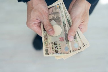 Japon Yen parası. Japon yenini elinizin altında tutun. Japonya 'nın değişim, alım, satım, birikim, yatırım, finans, döviz kuru, değer, muhasebe, uluslararası döviz kurunda kullanılan para birimi