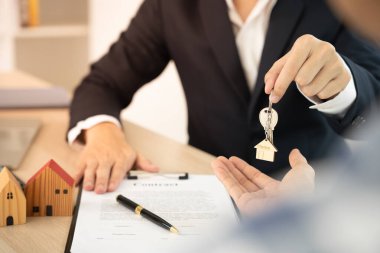 Kira, kiralama ve ev satma. Emlakçı menajeri yeni sahibine gülümsüyor. kira, satış, kredi finans, sigorta, satıcı, dağıtıcı, taksit, satın alma, satma, taşınma