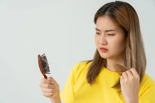 stock image Asian woman very sad and upset looking at damaged hair, hair loss, hair thinning problem, vitamin deficiency, baldness, postpartum, biotin, zinc, menstrual or endocrine disorders, hormonal imbalance