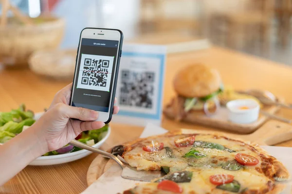 Woman use smartphone to scan QR code to pay in cafe restaurant with a digital payment without cash. Choose menu and order accumulate discount. E wallet, technology, pay online, credit card, bank app.