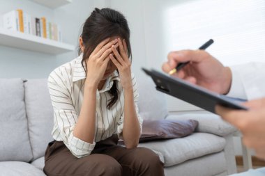 Akıl sağlığı sorunları olan bir kadın danışmanlık yapıyor. Psikiyatrist tedavi için hastanın durumunu kaydediyor. teşvik, sevgi ve aile sorunu, bipolar, depresyon hastası, intiharı koru