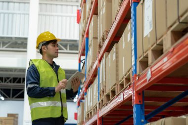 Asian male factory manager inspect goods in warehouse or inventory and check stock product. Transport logistic business shipping, delivery to customers. inspection, storehouse, storage, factory