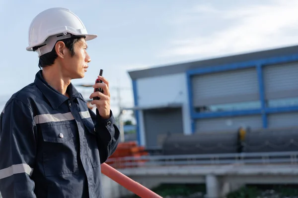 stock image maintenance and inspector. Maintenance engineers are using walky talky to inform the results of inspection of buildings and structures. Irrigation engineers are exploring sluice systems